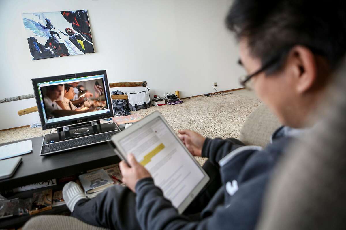 Francis Kong watches TV shows from a laptop set up in his living room while also working from his iPad from his living room on Friday, December 2, 2016 in Alameda, Calif.