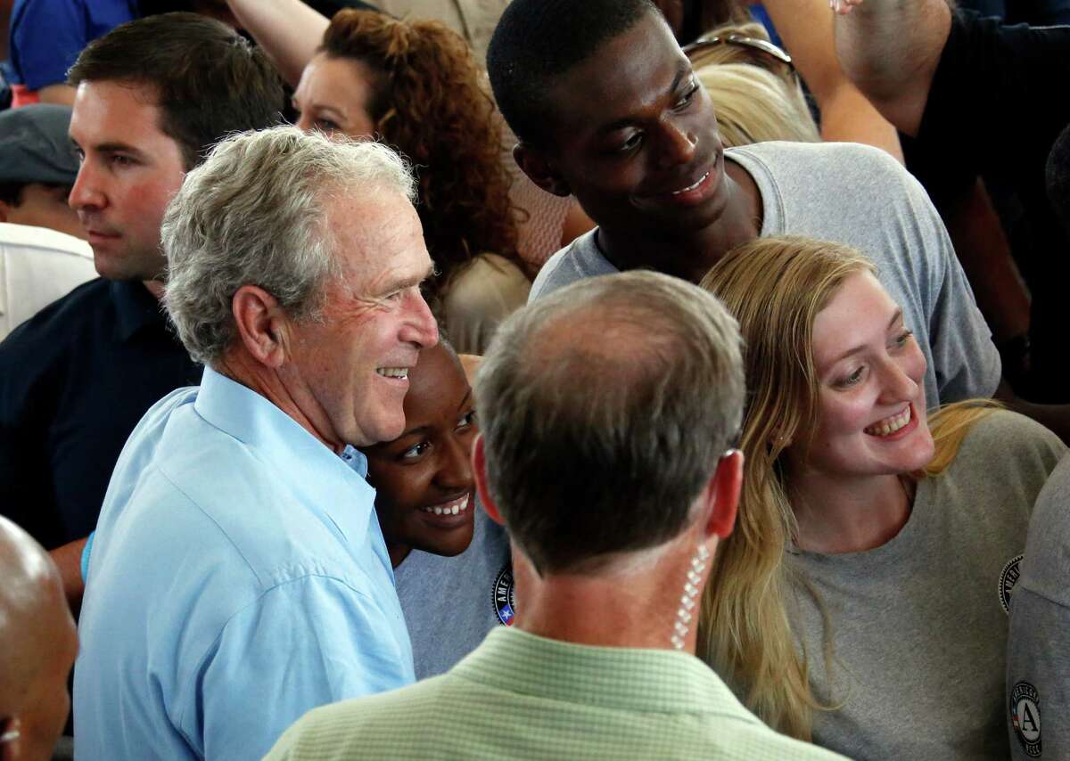 Former President George W. Bush takes a "selfie" with a group of AmeriCorps volunteers during a salute to first responders of Hurricane Katrina ﻿in last August in Gulfport, Miss.