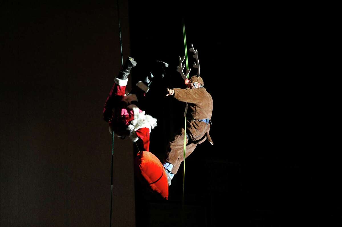 Brian VanOrsdel, as Santa, does a backflip in front of Ron Markey, as Rudolph, while rappelling down the Landmark Building during the 2016 Heights & Lights Rappel in Stamford, Conn. on Sunday, Dec. 4, 2016.