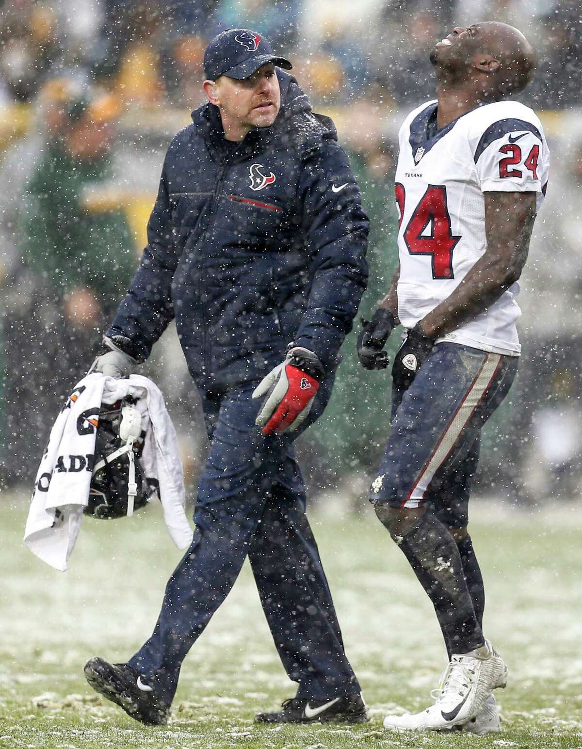 Houston Texans cornerback Johnathan Joseph (24) walks off the field with trainer Geoff Kaplan after suffering an injury during the third quarter of an NFL football game against the Green Bay Packers at Lambeau Field on Sunday, Dec. 4, 2016, in Green Bay.