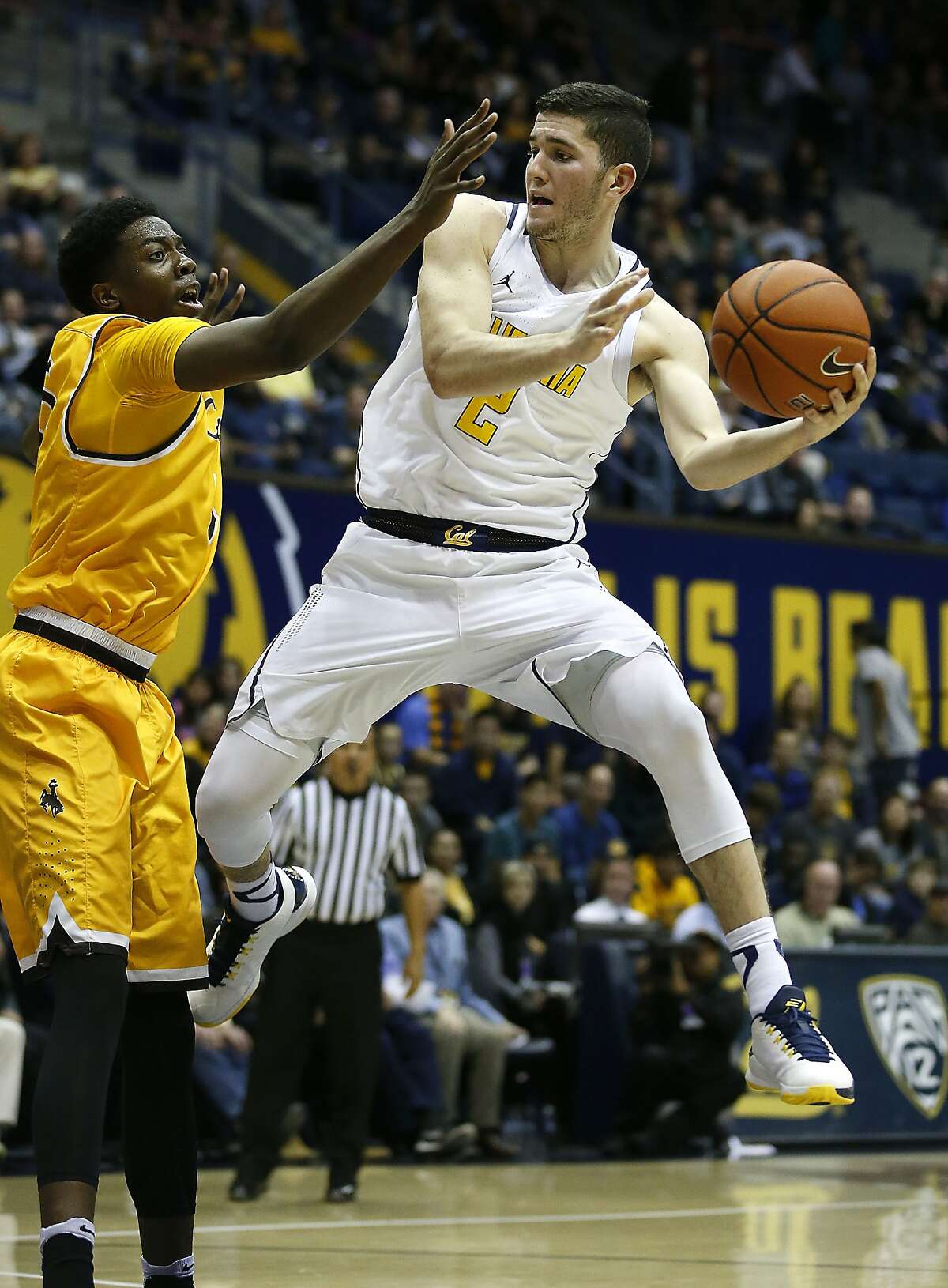 California guard Sam Singer (2) looks to pass the ball as Wyoming forward Alan Herndon defends during the second half of an NCAA college basketball game Friday, Nov. 25, 2016, in Berkeley, Calif. California won 71-61. (AP Photo/Tony Avelar)