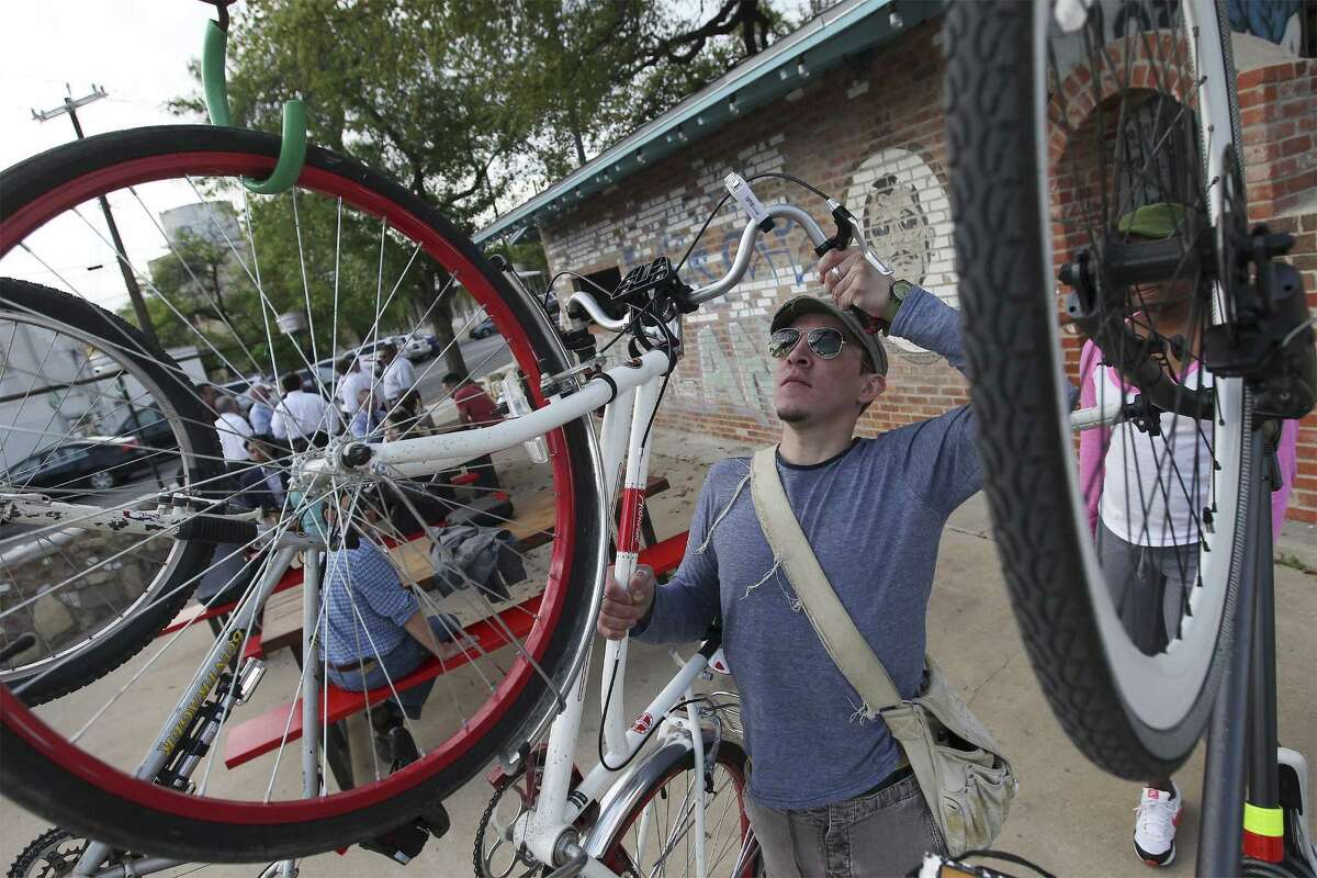 Patron Nicholas Kenna hangs a friend's bike at the entrance of reopened TacoLand. It’s opening a second location on the River Walk.