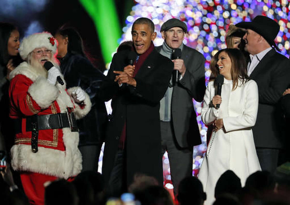 A diverse celebration: President Barack Obama, sings "Jingle Bells," with Santa Claus, James Taylor, Eva Longoria, and Garth Brooks during the lighting ceremony for the 2016 National Christmas Tree on the Ellipse near the White House, Thursday, Dec. 1, 2016 in Washington. (AP Photo/Alex Brandon)