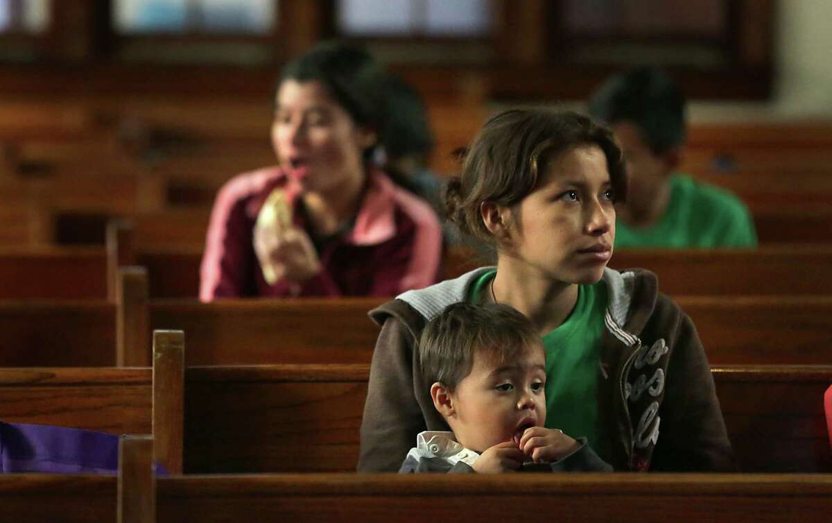 A young Central American mother sits with her son in the pews at San Antonio Mennonite Church where hundreds of immigrants from Central America have been dropped off by ICE. Volunteers mentioned they went out to buy blankets and air mattresses, and the last bus dropped off another group at 3 A.M. on Monday, Dec. 5, 2016.