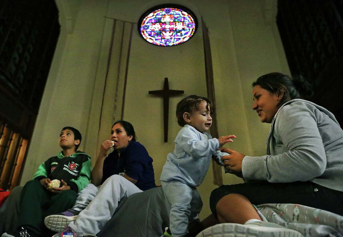 Maria Teresa Quinones, right, plays with her 1 year old son Angel Gael Vanegas from Honduras, as Xiomara Vega Morales, 33 sits with her son Marlon Vega Morales, 8, left, of Guatemala in the sanctuary at the San Antonio Mennonite Church where hundreds of immigrants from Central America have been dropped off by ICE. Volunteers mentioned they went out to buy blankets and air mattresses, and the last bus dropped off another group at 3 A.M. on Monday, Dec. 5, 2016.