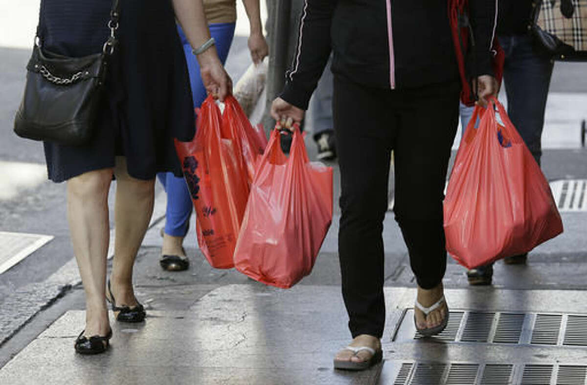 FILE - In this Sept. 20, 2016, file photo, women walk with plastic bags through Chinatown in San Francisco. California voters have narrowly approved a statewide ban on single-use plastic carryout bags. Proposition 67 was placed on the November 8, 2016, ballot by plastic bag industry supporters to try to overturn a ban approved by the state legislature two years ago. (AP Photo/Eric Risberg, File)