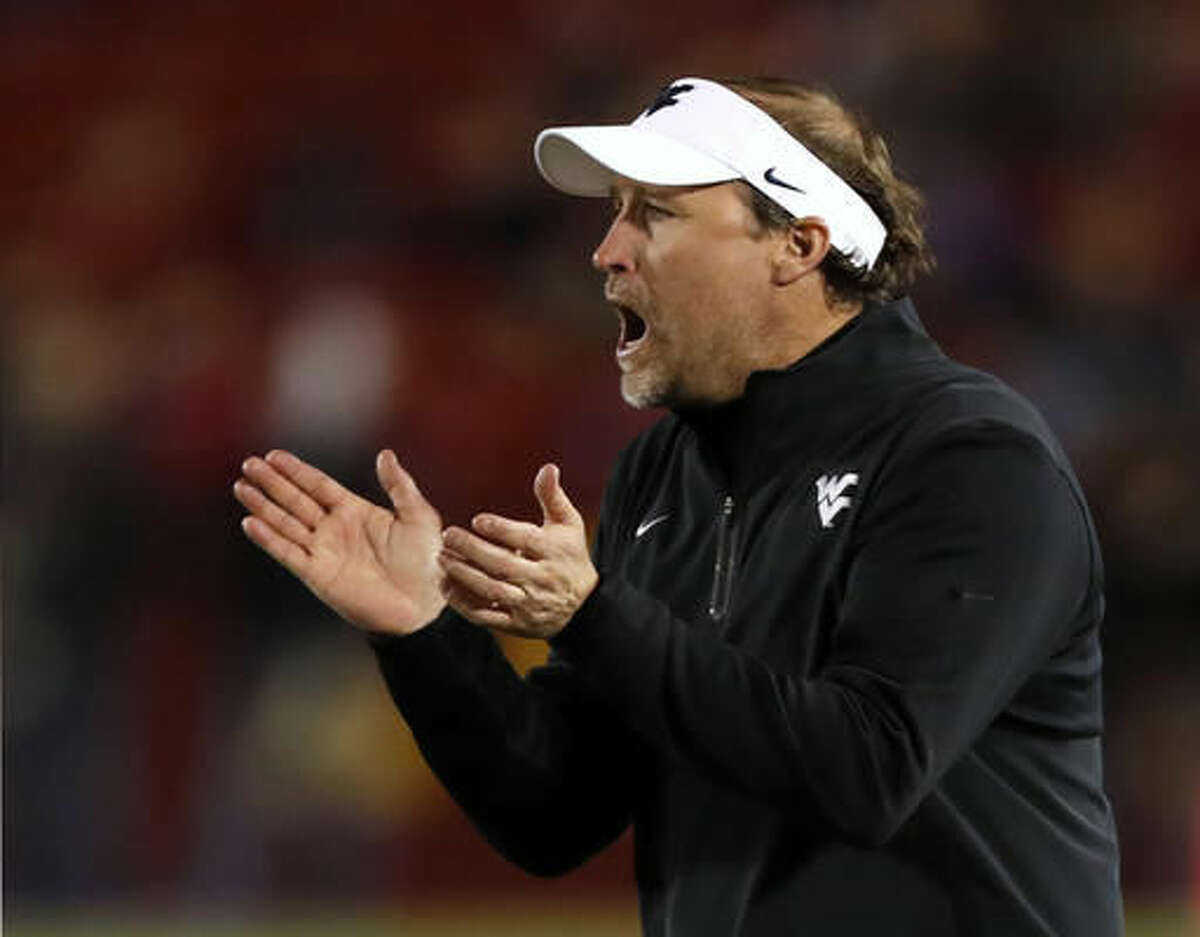 FILE - In this Nov. 26, 2016, file photo, West Virginia head coach Dana Holgorsen reacts during the second half of an NCAA college football game against Iowa State, in Ames, Iowa. No. 14 Baylor and West Virginia meet Saturday, Dec. 3, 2016 in their regular-season finale with both teams heading in opposite directions. West Virginia is going after a 10-win regular season, while Baylor is trying to break a five-game losing streak after starting 6-0. (AP Photo/Charlie Neibergall, File)