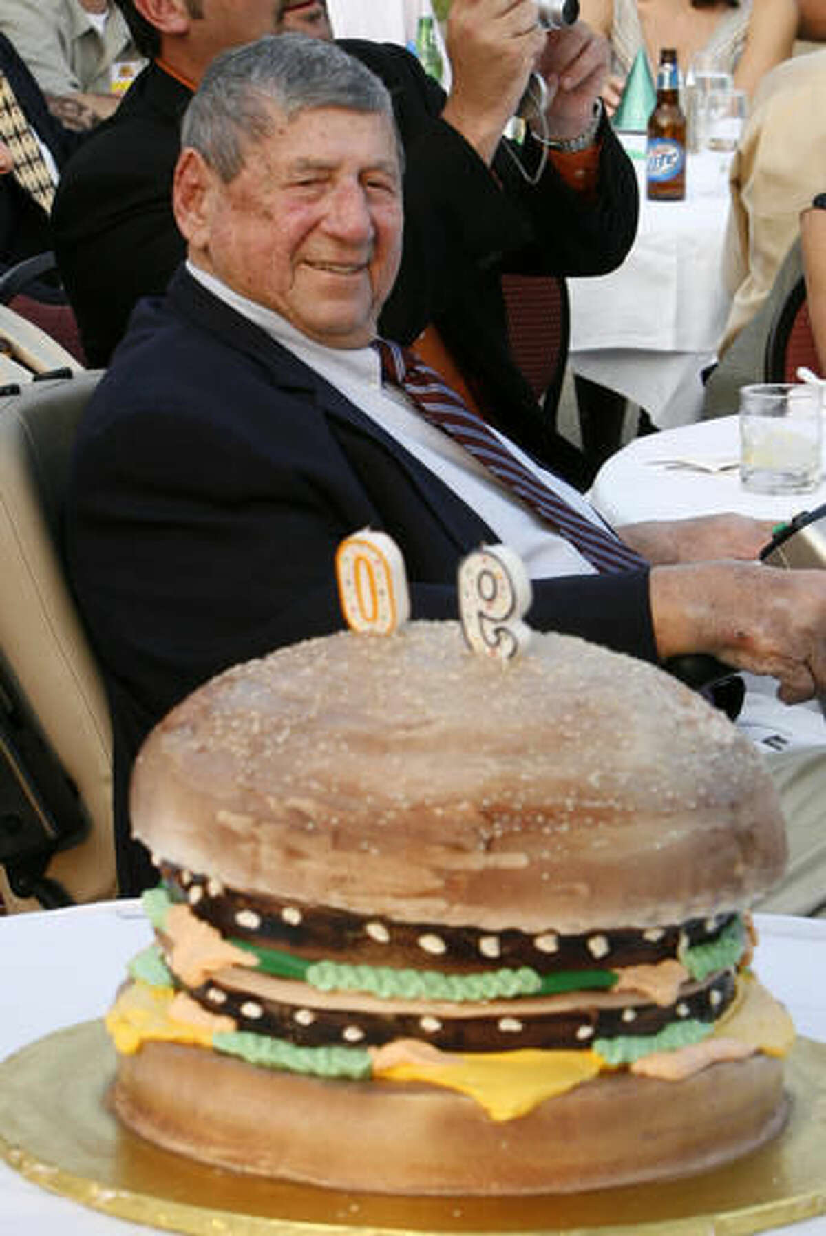 FILE - In this Aug. 21, 2008, file photo, Big Mac creator Michael "Jim" Delligatti sits behind a Big Mac birthday cake at his 90th birthday party in Canonsburg, Pa. Delligatti, the Pittsburgh-area McDonald's franchisee who created the Big Mac in 1967, has died. He was 98. (AP Photo/Gene J. Puskar, File)
