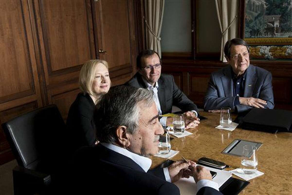 Turkish Cypriot leader Mustafa Akinci, left, speaks with Greek Cypriot President Nicos Anastasiades, right, next to Special Adviser to the United Nations Secretary-General on Cyprus Espen Barth Eide, 2nd right, and Elizabeth Spehar, Deputy to the Secretary-General's Special Adviser on Cyprus, 2nd left, during the Cyprus Talks, in Mont Pelerin, Switzerland Sunday, Nov. 20, 2016. (Jean-Christophe Bott/Keystone via AP)