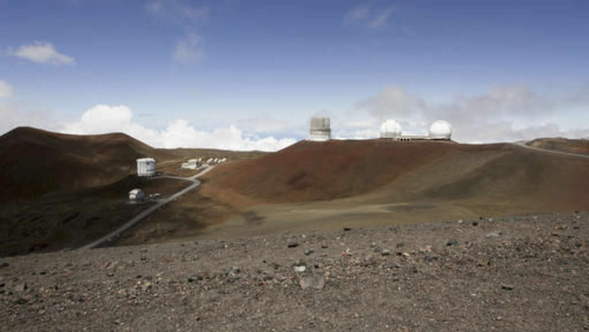 FILE - In this Aug. 31, 2015 file photo, observatories sit atop Hawaii's Mauna Kea, near Hilo, Hawaii. Hearings are still underway for a permit to build what would be one of the world's largest telescopes in Hawaii, but a group challenging the project is already appealing to the state Supreme Court. Thirty Meter Telescope opponents are challenging various decisions that have been made regarding contested-case proceedings, including affirming the hearings officer and an order limiting cross-examination to 30 minutes per party. (AP Photo/Caleb Jones, File)