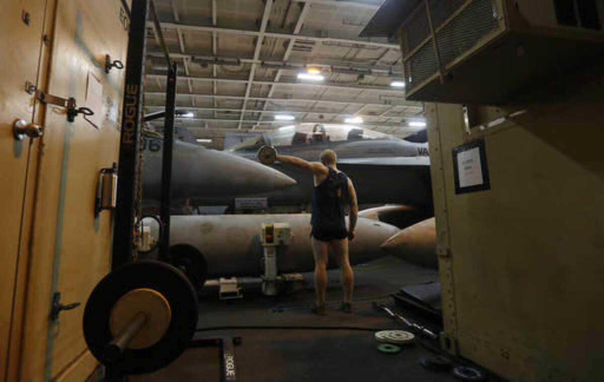 In this picture taken on Monday, Nov. 21, 2016, U.S. Navy sailor works out in a gym at the U.S.S. Dwight D. Eisenhower aircraft carrier. The carrier is currently deployed in the Persian Gulf, supporting Operation Inherent Resolve, the military operation against Islamic State extremists in Syria and Iraq. (AP Photo/Petr David Josek)