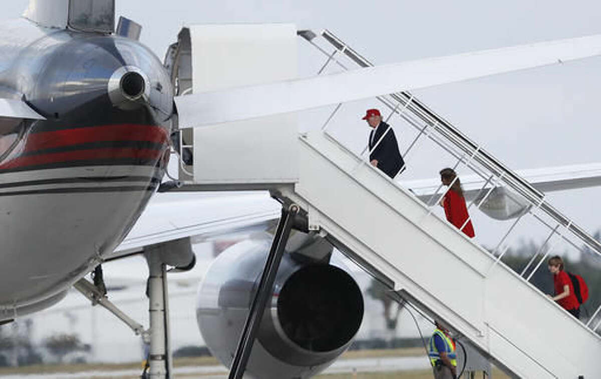 President-elect Donald Trump, followed by his wife Melania Trump and son Barron Trump, boards his plane at Palm Beach International Airport, Sunday, Nov. 27, 2016, in West Palm Beach, Fla., en route to New York. (AP Photo/Carolyn Kaster)
