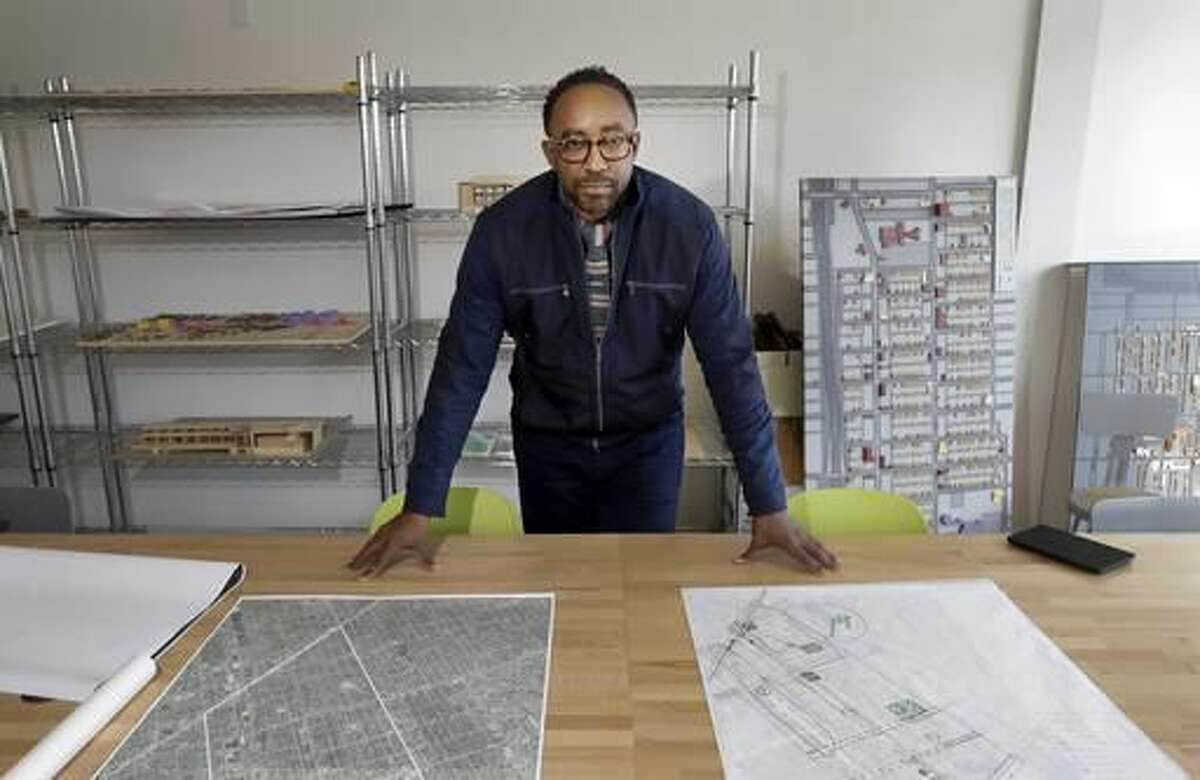 In a Wednesday, Oct. 19, 2016, photo, Hajj Flemings, who won nearly $165,000 from the Knight Foundation Cities Challenge competition a year earlier, poses for a picture at the Detroit Center of Design and Technology in Detroit. Flemings won the grant for his proposal to help small businesses in Detroit develop an online presence and a brand. (AP Photo/Carlos Osorio)