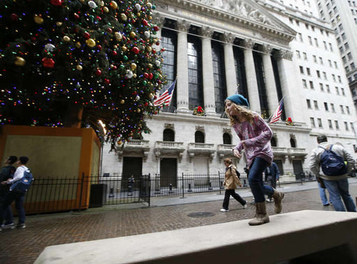In this photo taken Dec. 24, 2015, a youngster runs along a concrete bench across from the New York Stock Exchange on Christmas Eve, in New York, where warm and balmy temperatures shattered records. A new study says broken daily heat records are going to be far more common than cold ones in the U.S. Normally, the nation should generally have about the same number of hot and cold records. But that’s not happening with more than twice as many heat records this decade than cold. (AP Photo/Kathy Willens)