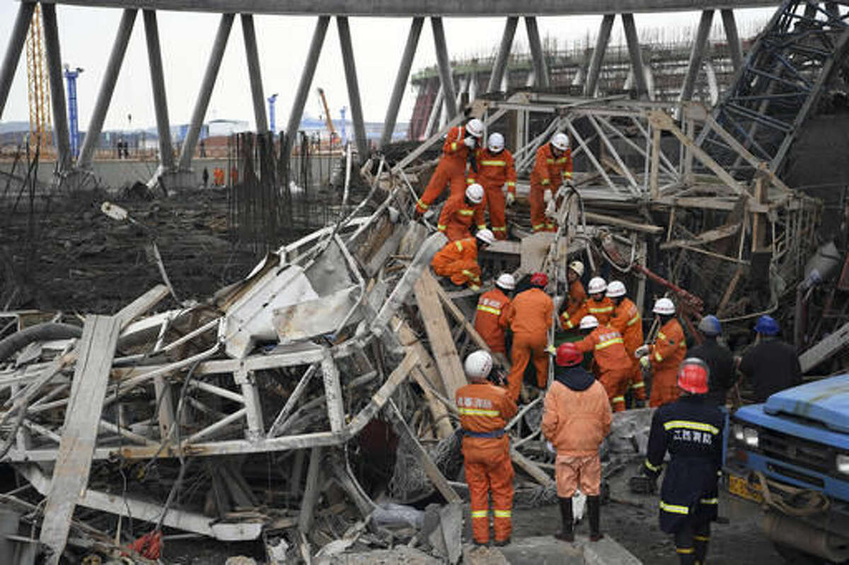 In this photo released by Xinhua News Agency, rescue workers look for survivors after a work platform collapsed at the Fengcheng power plant in eastern China's Jiangxi Province, Nov. 24, 2016. State media reported dozens were killed after the scaffolding tumbled down. (Wan Xiang/Xinhua via AP)