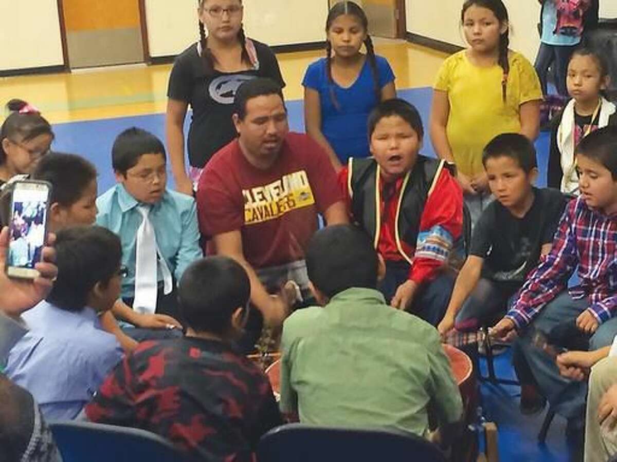 ADVANCE FOR THE WEEKEND OF NOV 18-19 AND THEREAFTER - In a Nov. 2, 2016 photo, Ethan Fightingbear leads a drum group made up of students from Arapaho schools, to celebrate the release of a new application for smart phones and tablets that translates words from English to the Arapaho language. Arapaho elders regularly met to develop the words and translations for the app, ultimately creating 24 categories. (Carl Manning/The Ranger via AP)