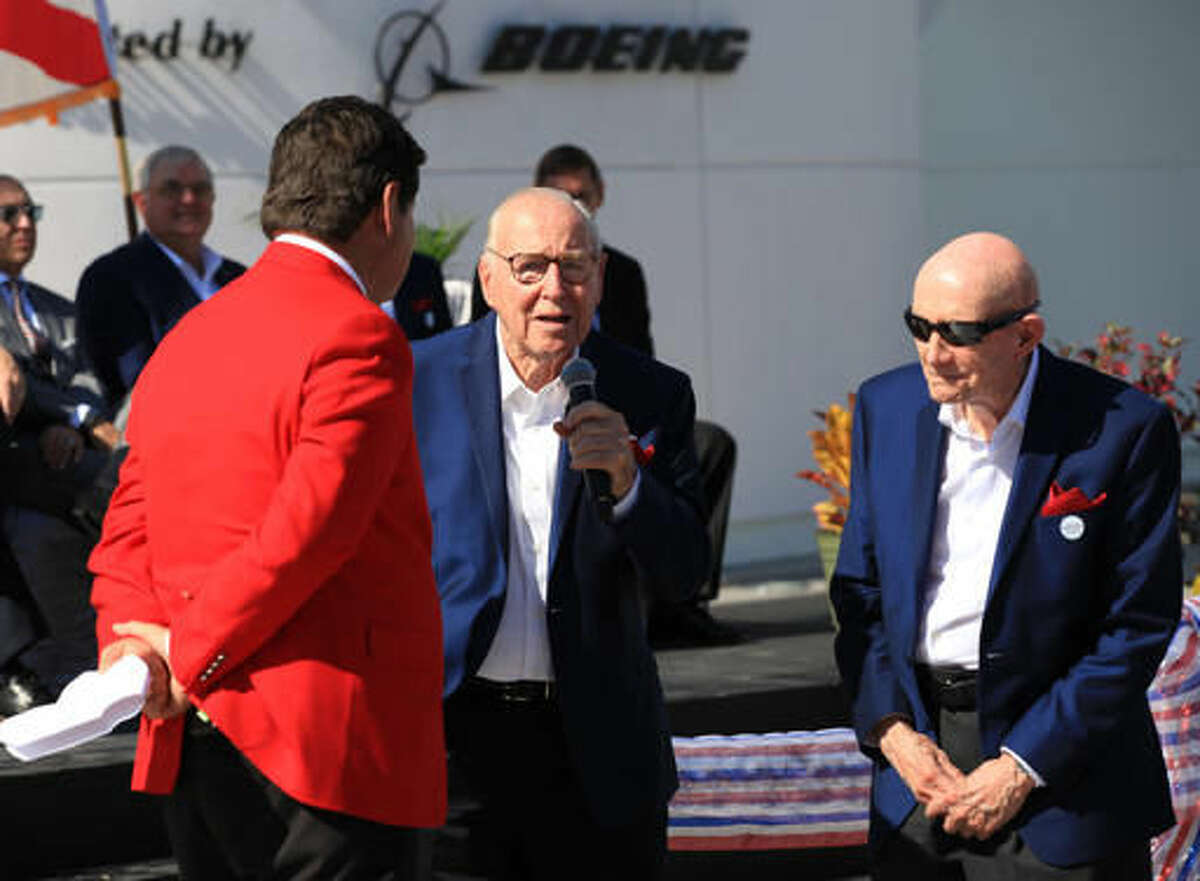 Astronaut Jim Lovell, center, speaks, accompanied by fellow astronaut Tom Stafford, right, during the ribbon cutting ceremony for the Heroes and Legends exhibit at the Kennedy Space Center Visitor Complex in Florida on Friday, Nov. 11, 2016. At left is the master of ceremonies, John Zarrella, formerly of CNN. (Kevin O'Connell/NASA via AP)