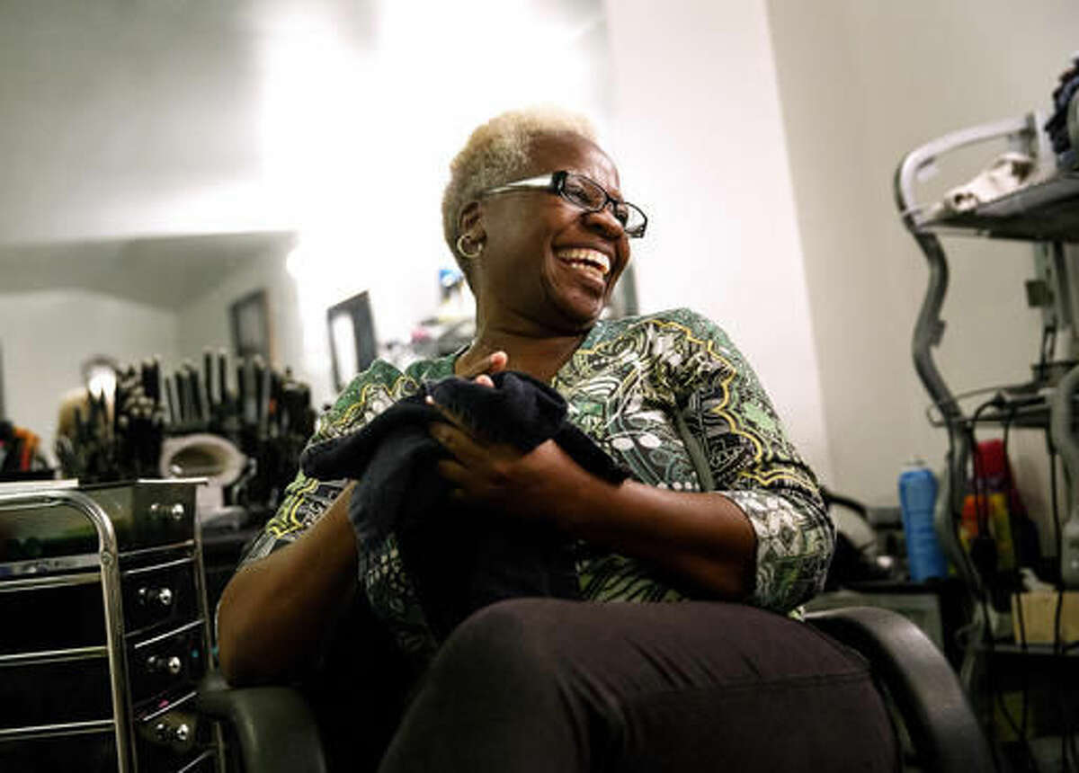 In this Oct. 20, 2016 photo, Marcella Kincaid who was convicted of a felony in 1991, smiles in her hair salon in Springfield, Ill. Kincaid was convicted of selling cocaine, but was granted clemency recently by Gov. Bruce Rauner and her record could soon be cleared. Now a substance abuse counselor for the Family Guidance Center, Kincaid said getting her record expunged paves the way for her pursuing her dream of opening up multiple sober living homes in Springfield. (Rich Saal/The State Journal-Register via AP)