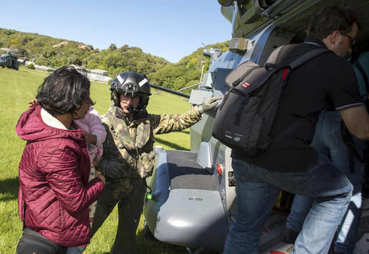 In this image provided by the Royal New Zealand Defense Force, tourists are evacuated by helicopter from Kaikoura following Monday's earthquake, in New Zealand, Tuesday, Nov. 15, 2016. New Zealand military officials said Tuesday that they had evacuated about 140 people by helicopter from a coastal town and were expecting that number to rise to 200 by the end of the day, as a major rescue operation unfolded following a powerful earthquake. (Royal New Zealand Defence Force via AP)