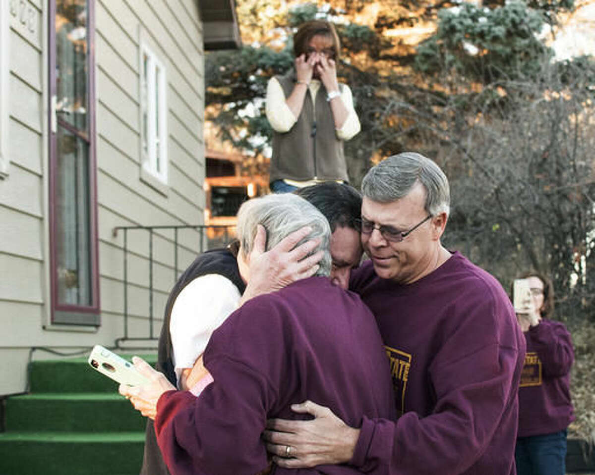 In this Nov. 11, 2016, photo, Mike Jennings, back, hugs his sister Sandy Erby and brother Jim Reimer at Jennings' home in Havre, Mont. The three siblings, the last survivors of seven who were given up for adoption, met for the first time. (Teresa Getten/Havre Daily News via AP)