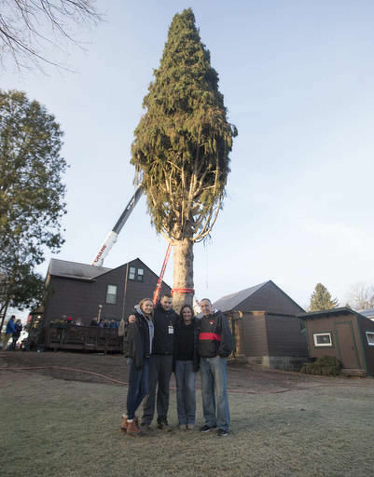 Graig Eichler, right, his wife Angie and their children Ava and Brock pose in front of a 94-foot Norway spruce that will serve as the Christmas tree at Rockefeller Center on Thursday, Nov. 10, 2016, in Oneonta, N.Y. The spruce is due to arrive Saturday in Manhattan, about 140 miles away. (AP Photo/Mike Groll)