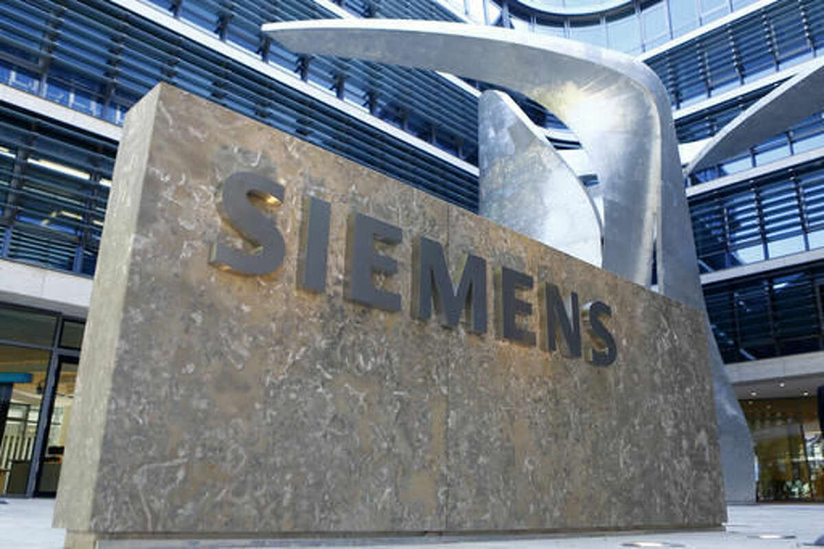 FILE - In this June 24, 2016 file picture the logo of German industrial conglomerate Siemens is pictured prior to opening ceremony at the new headquarters in Munich, Germany. German industrial equipment maker Siemens AG says it has agreed to buy U.S.-based software firm Mentor Graphics Corp. for US $4.5 billion. The companies said in a joint statement Monday Nov. 14, 2016 that Mentor's board recommended shareholders approve the deal. (AP Photo/Matthias Schrader,file)