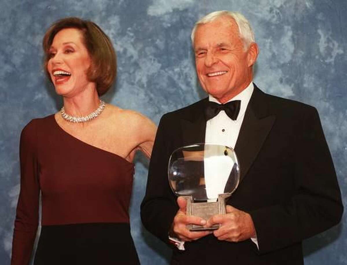FILE - In this Saturday, Nov. 1, 1997, file photo, Television executive Grant Tinker holds up his Hall of Fame award alongside his ex-wife Mary Tyler Moore at the Academy of Television Arts & Sciences' 13th Annual Hall of Fame induction ceremonies in the North Hollywood section of Los Angeles. Tinker, who brought "The Mary Tyler Moore Show" and other hits to the screen as a producer and a network boss, has died. Tinker died Monday, Nov. 28, 2016, at his home in Los Angeles, according to his son, Mark Tinker. (AP Photo/Chris Pizzello, File)