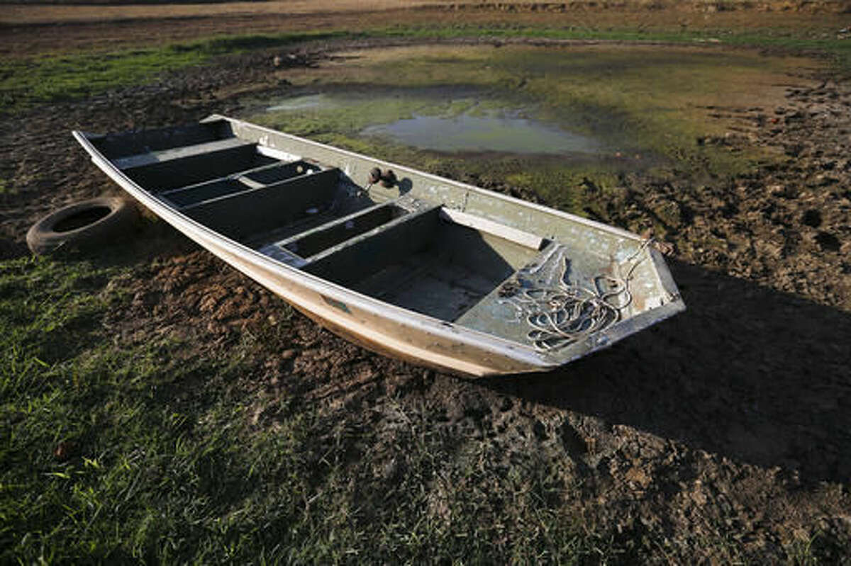 FILE - In this Wednesday, Oct. 26, 2016 file photo, an abandoned boat sits in the remains of a dried out pond in Dawson, Ala. Though water shortages have yet to drastically change most people's lifestyles, southerners are beginning to realize that they'll need to save their drinking supplies with no end in sight to an eight-month drought. Already, watering lawns and washing cars is restricted in some parts of the South, and more severe water limits loom if long-range forecasts of below-normal rain hold true through the rest of 2016. (AP Photo/Brynn Anderson, File)