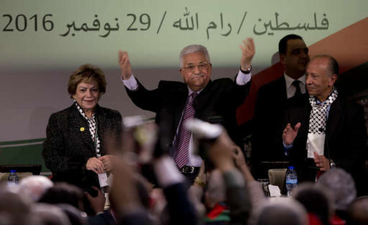 Palestinian President Mahmoud Abbas, center, is greeted by fellow Fatah members as he arrives during the second day of the Fatah party conference, in the West Bank city of Ramallah, Wednesday, Nov. 30, 2016. Palestinian Fatah movement holds its seventh conference in Ramallah with some fourteen hundred members participating and led by Palestinian President Mahmoud Abbas. The conference is to elect the party's two main decision making bodies. Arabic reads " Palestine, Ramallah, November 29, 2016." (AP Photo/Majdi Mohammed)