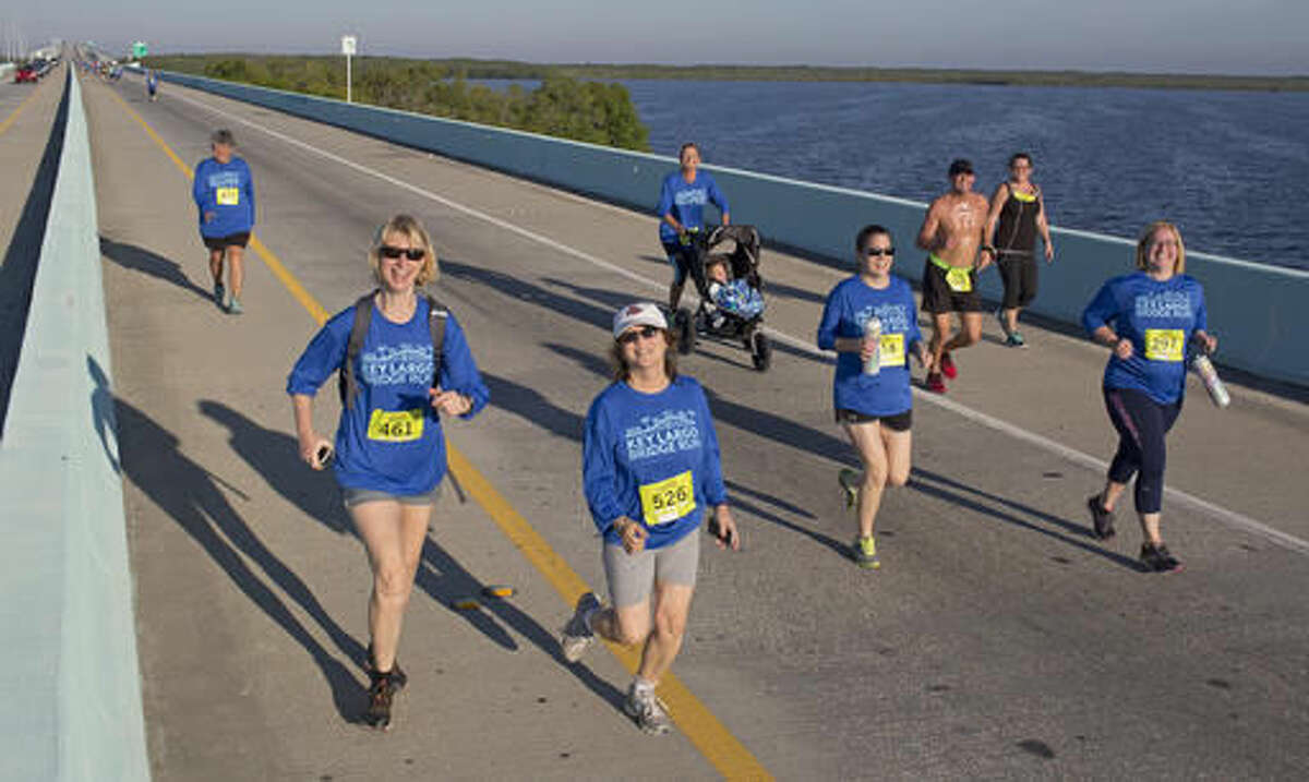 In this photo provided by the Florida Keys News Bureau, competitors in the 5k division of the Key Largo Bridge Run head to the finish line Saturday, Nov. 12, 2016. Some 465 registered entrants competed in 5k, 10k and half-marathon classes that took participants out and back over the 1.4-mile-long Jewfish Creek Bridge and land areas. (Bob Care/Florida Keys News Bureau via AP )