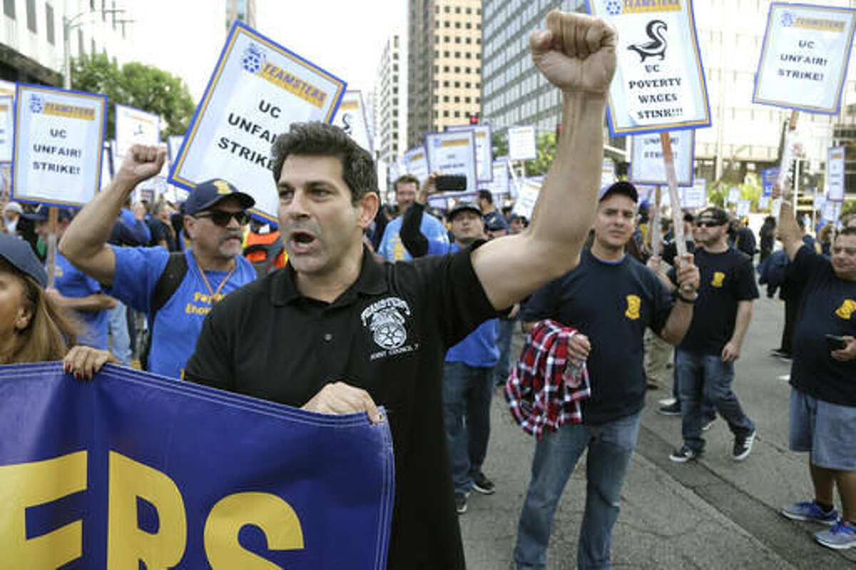 Several hundred union members wearing Teamsters shirts and hats participate in a rally at the University of California Los Angeles carrying signs reading "fair contract now!" and "UC unfair!" Wednesday, Nov. 16, 2016, in Los Angeles. Electricians, elevator mechanics, plumbers and other workers at UCLA walked off the job Wednesday to demand higher wages in a daylong strike. No major disruptions were reported. (AP Photo/Nick Ut)