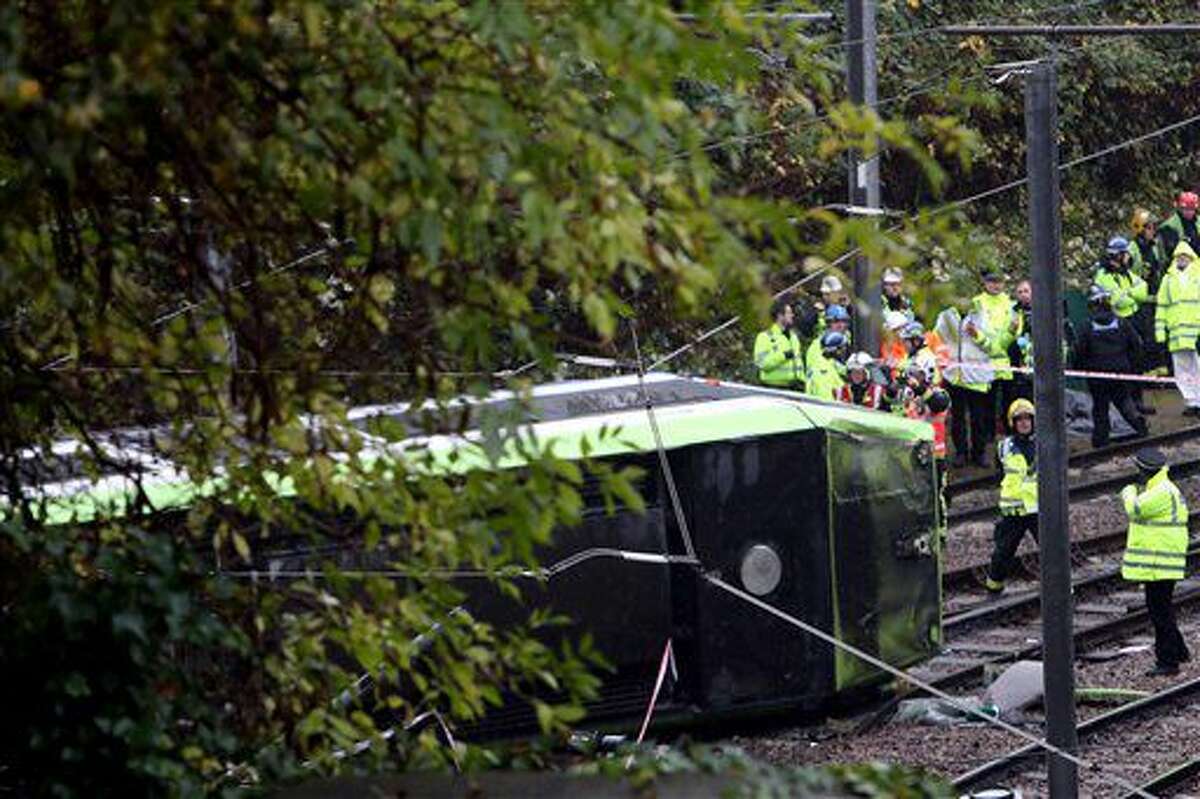 Emergency service workers attend the scene of a derailed tram in Croydon, south London, Wednesday Nov. 9, 2016. A tram derailed in London before dawn on Wednesday, leaving at least 50 people injured and several trapped, the emergency services said. (Steve Parsons/PA via AP)