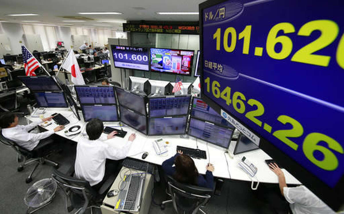 Money traders watch computer screens with the day's exchange rate between yen and the U.S. dollar at a foreign exchange brokerage in Tokyo, Wednesday, Nov. 9, 2016. Asian shares have shed early gains, tumbling Wednesday as Donald Trump gained the lead in the electoral vote count in the presidential election. Dow and S&P futures also plunged. Earlier, investors had appeared persuaded that Hillary Clinton, seen as a more stable choice, would prevail.(AP Photo/Shizuo Kambayashi)