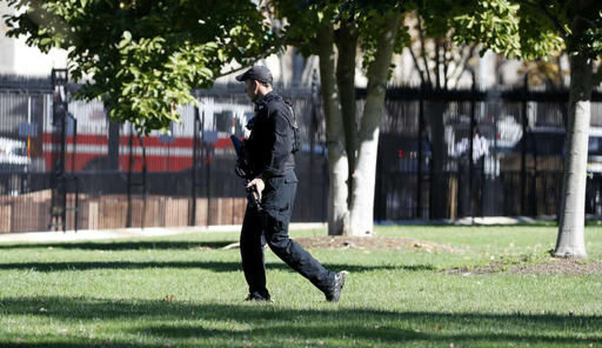 A U.S. Secret Service officer walks the grounds near the North Portico during a lock-down at the White House, Saturday, Nov. 5, 2016 in Washington. According to the Secret Service, a Secret Service Uniformed Division Officer noticed a man with a weapon in a holster while walking on Pennsylvania Avenue near Madison Place. The officer confronted the man and a brief struggle ensued, before the man was arrested. President Obama was not at the White House during the incident. (AP Photo/Alex Brandon)