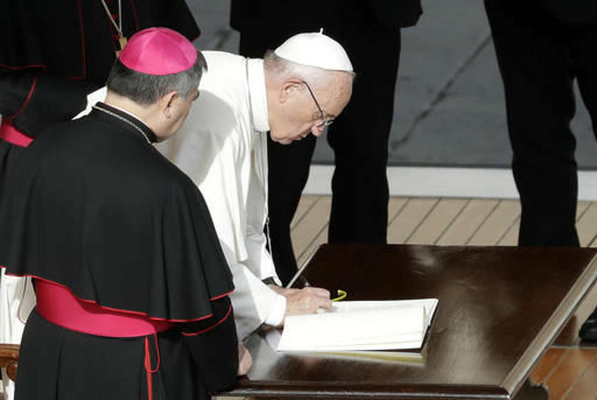 Pope Francis signs a letter at the end of a Mass on the occasion of the closing of the Holy Door of St. Peter's Basilica at the Vatican, Sunday, Nov. 20, 2016. The Vatican said the letter, addressed to all the church, expressed the pope's intention that the church can continue to live out the mercy with the same intensity felt during the entire special Jubilee Holy Year. (AP Photo/Gregorio Borgia)