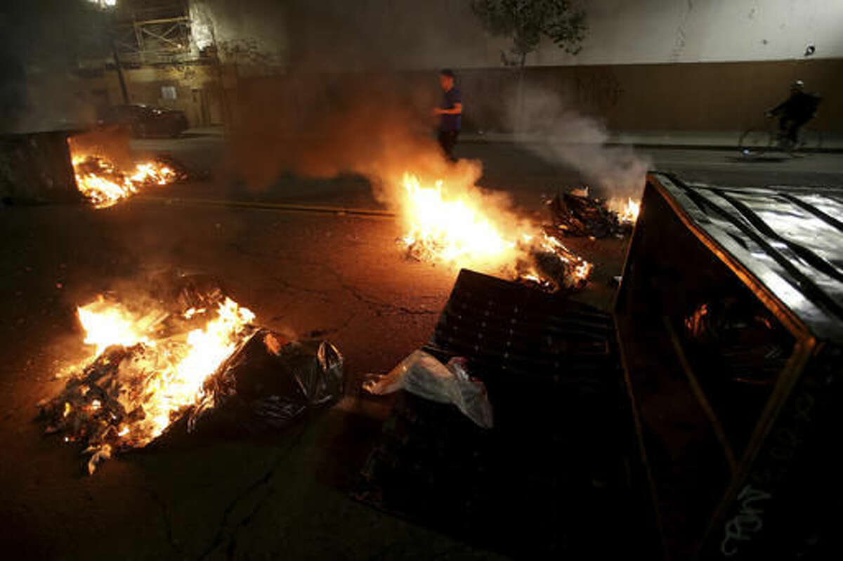 Multiple fires are lit in dumpsters and trash cans during protests in downtown Oakland, Calif., late Tuesday, Nov. 8, 2016. President-elect Donald Trump’s victory set off multiple protests. (Jane Tyska/Bay Area News Group via AP)