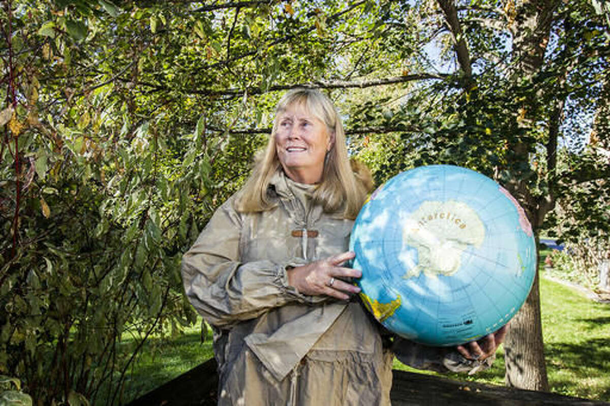 In this Thursday Oct. 13, 2016 photo, Betty Trummel poses for a portrait showing Antarctica on a globe in Crystal Lake, Ill. Trummel, a former elementary school teacher, will travel to Antarctica in December for three weeks. She's one of 78 women chosen from around the world to participate in Homeward Bound, an education and research expedition. This will be her fourth time visiting Antarctica. (Sarah Nader/Northwest Herald via AP)