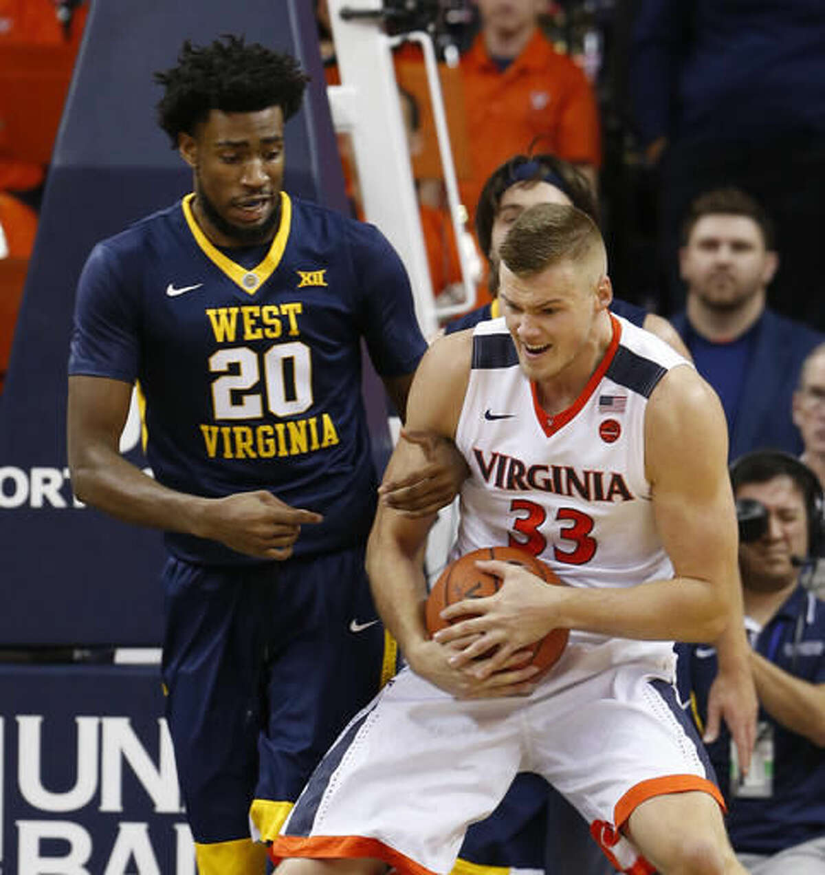 Virginia center Jack Salt (33) and West Virginia forward Brandon Watkins (20) fight for a rebound during the first half of an NCAA college basketball game in Charlottesville, Va., Saturday, Dec. 3, 2016. (AP Photo/Steve Helber)