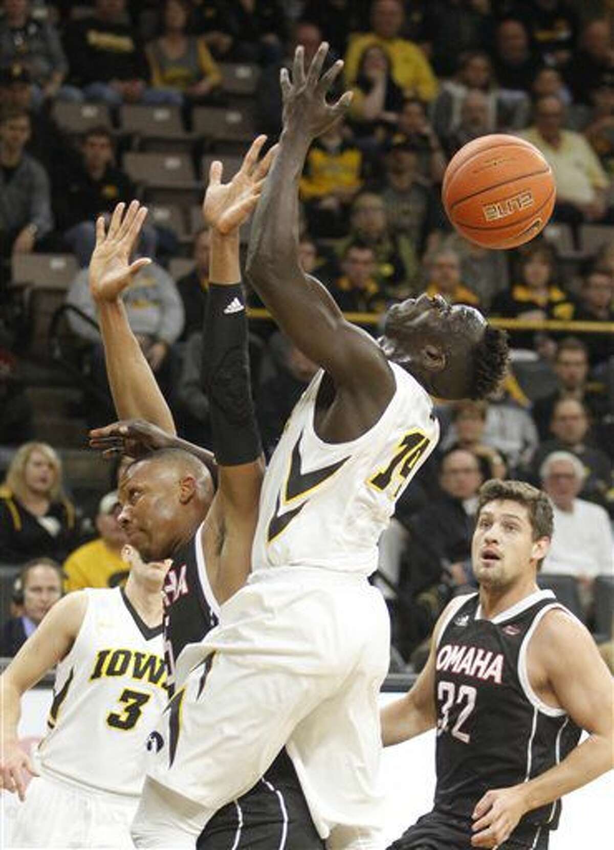 Iowa's Peter Jok (14) is fouled by Omaha's Tre'Shawn Thurman (15) during the first half of an NCAA college basketball game, Saturday, Dec. 3, 2016, in Iowa City, Iowa. (AP Photo/Matthew Holst)