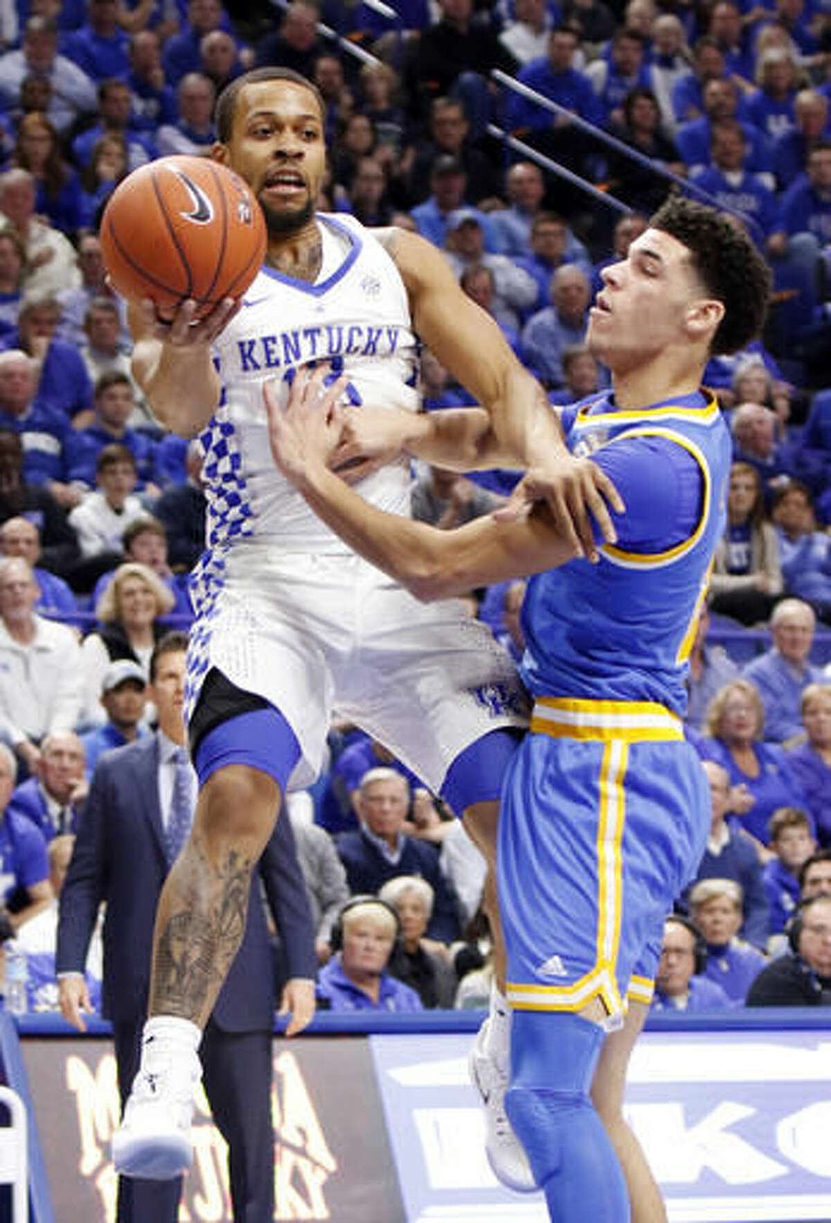 Kentucky's Isaiah Briscoe, left, passes near UCLA's Lonzo Ball during the first half of an NCAA college basketball game, Saturday, Dec. 3, 2016, in Lexington, Ky. (AP Photo/James Crisp)