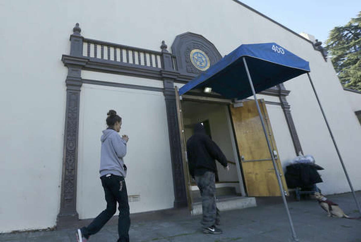 A woman and a man walk into the American Legion Hall, which served a free Thanksgiving dinner, in Antioch, Calif., Tuesday, Nov. 29, 2016. San Francisco Bay Area health officials were trying to determine if three people who died and five who were sickened after eating the Thanksgiving dinner at a church event held at American Legion Hall got sick there or at the assisted living facility where they all lived. (AP Photo/Jeff Chiu)