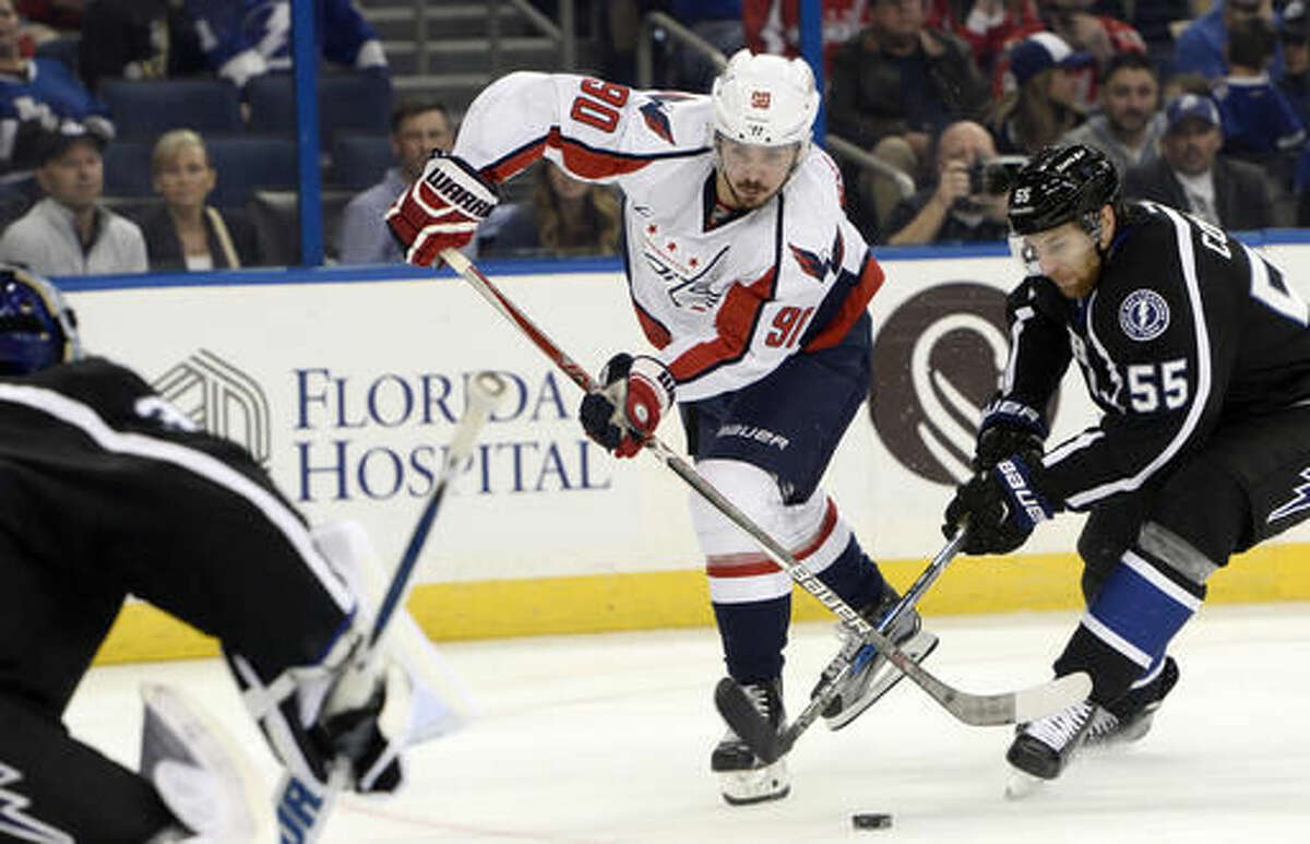 Tampa Bay Lightning defenseman Braydon Coburn (55) knocks the puck away as Washington Capitals left wing Marcus Johansson (90) looks for a shot during the first period of an NHL hockey game Saturday, Dec. 3, 2016, in Tampa, Fla. (AP Photo/Jason Behnken)
