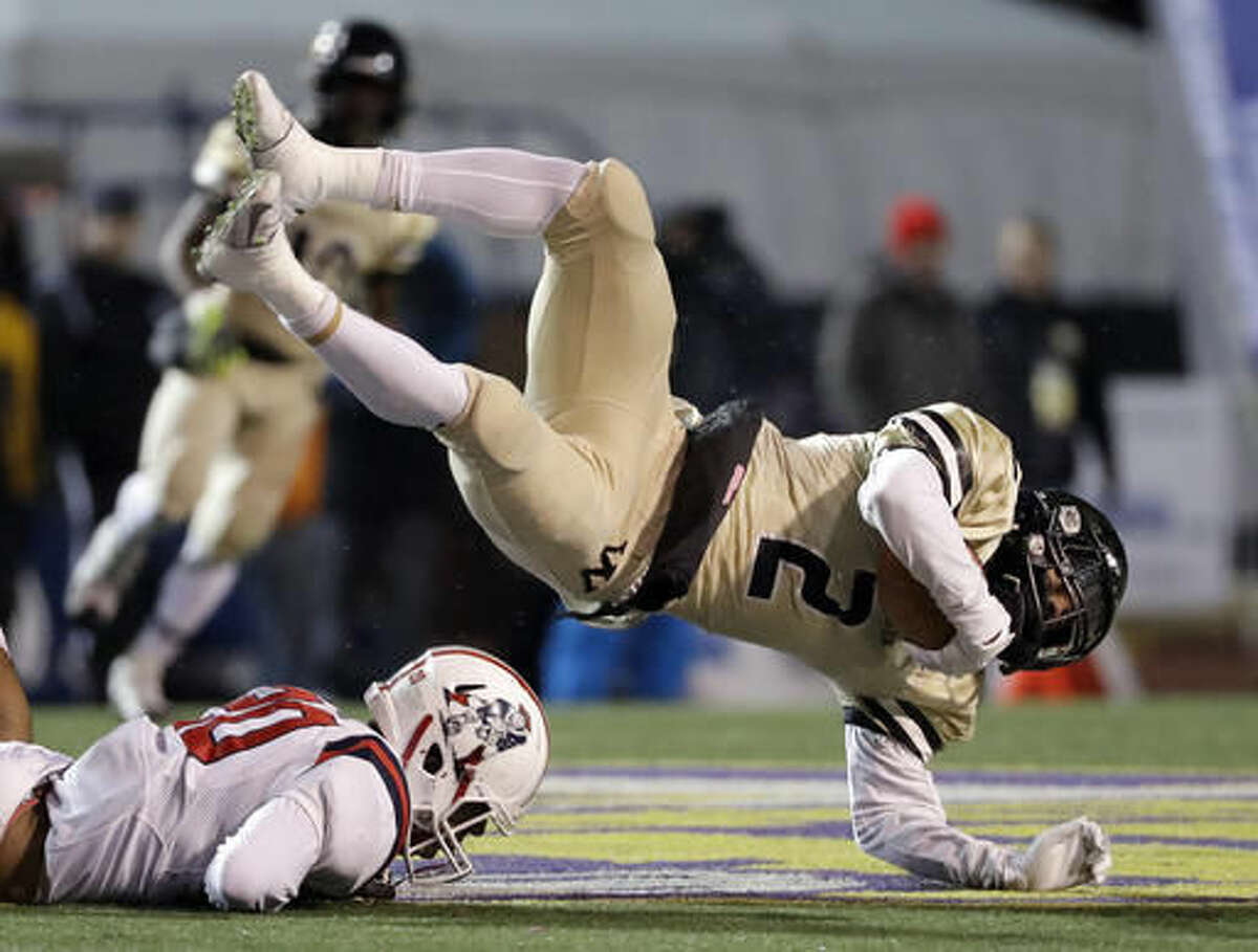 Whitehaven High School wide receiver Markerion Johnson (2) falls over Oakland High School linebacker Brandon Turner (20) during the first half of the Division I Class 6A Tennessee high school football championship game Saturday, Dec. 3, 2016, in Cookeville, Tenn. (AP Photo/Mark Humphrey)