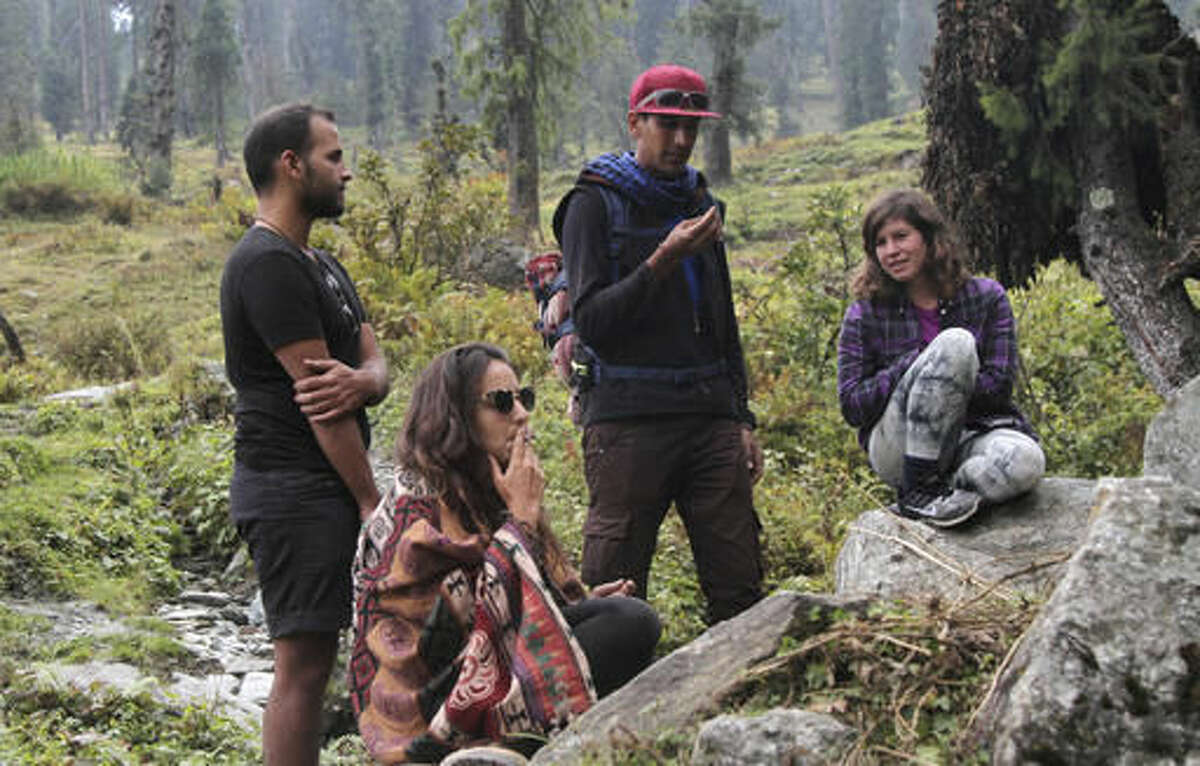 In this Wednesday, Oct. 5, 2016 photo, Israeli tourist Amit, only one name given, seated left, smokes a joint after a hike with friends at Malana village in the northern Indian state of Himachal Pradesh. Malana has become one of the world's top stoner destinations, and a symbolical battleground for India's fight against 'charas,' the black and sticky hashish that has made the village famous. The valley in the Indian Himalayas is teeming with young Israelis, many draped in colorful shawls and wearing their hair into ropey dreadlocks, who come for a therapeutic experience after years of military service. (AP Photo/Rishabh R. Jain)