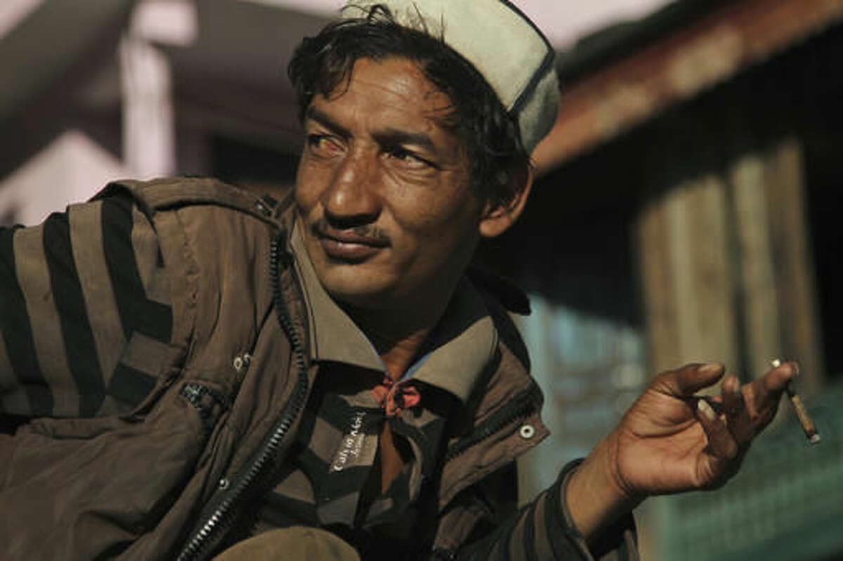 In this Thursday, Oct. 6, 2016 photo, a local villager smokes a joint of hashish at the village square in Malana in the northern Indian state of Himachal Pradesh. Nestled deep in the higher reaches of the Indian Himalayas, Malana has become one of the world's top stoner destinations, and a symbolical battleground for India's fight against 'charas,' the black and sticky hashish that has made the village famous. (AP Photo/Rishabh R. Jain)
