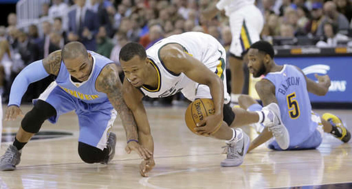 Denver Nuggets guard Jameer Nelson, left, and Utah Jazz guard Rodney Hood, center, battle for a loose ball, as Denver Nuggets guard Will Barton (5) looks on during the first half of an NBA basketball game Saturday, Dec. 3, 2016, in Salt Lake City. (AP Photo/Rick Bowmer)
