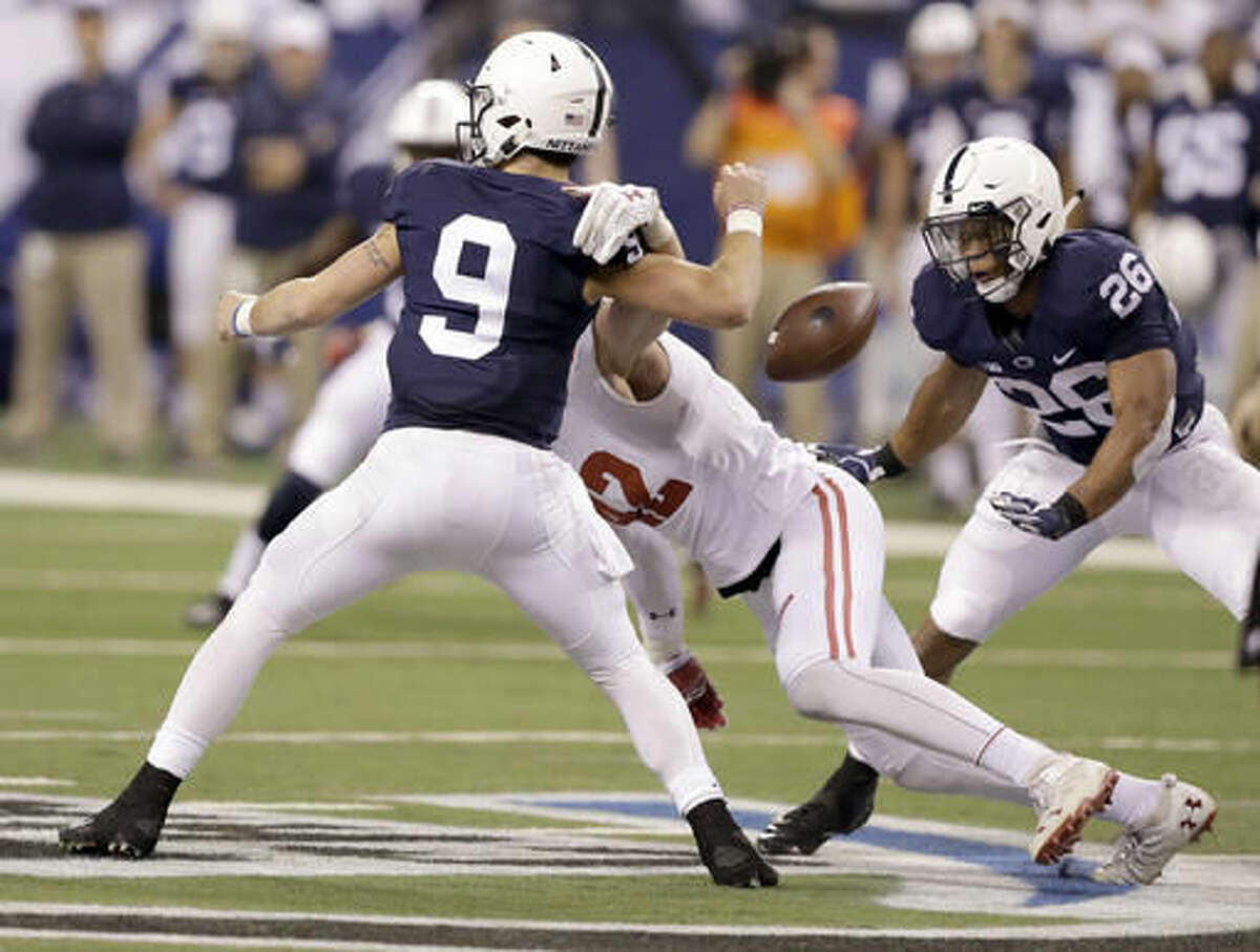 Penn State quarterback Trace McSorley (9) fumbles as he is sacked by Wisconsin's T.J. Watt, center, as Penn State's Saquon Barkley, right, watches during the first half of the Big Ten championship NCAA college football game Saturday, Dec. 3, 2016, in Indianapolis. Watt recovered the fumble. (AP Photo/Michael Conroy)