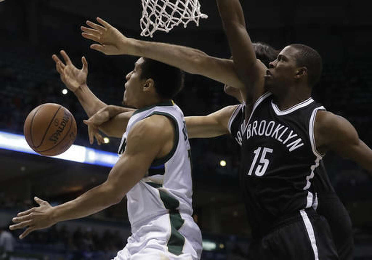 Milwaukee Bucks' Malcolm Brogdon is fouled shooting past Brooklyn Nets' Luis Scola and Isaiah Whitehead (15) during the first half of an NBA basketball game Saturday, Dec. 3, 2016, in Milwaukee. (AP Photo/Morry Gash)