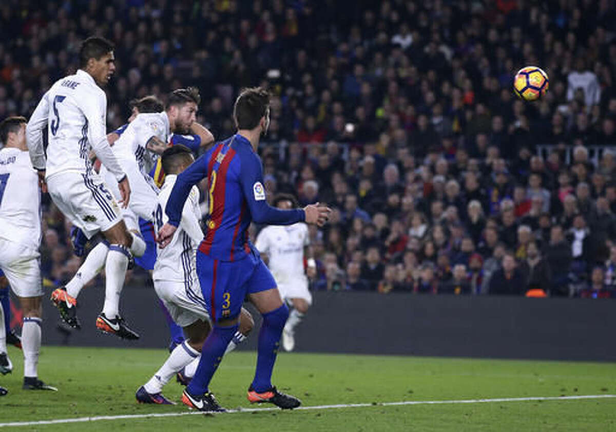 Real Madrid's Sergio Ramos, center left, scores his side's first goal during the Spanish La Liga soccer match between FC Barcelona and Real Madrid at the Camp Nou in Barcelona, Spain, Saturday, Dec. 3, 2016. (AP Photo/Manu Fernandez)