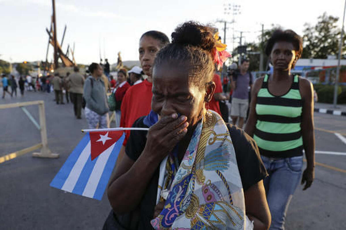 A woman cries after watching the ashes of Fidel Castro leave the Antonio Maceo plaza heading to the Santa Ifigenia cemetery for a private funeral ceremony in Santiago, Cuba, , Sunday, Dec. 4, 2016.(AP Photo/Natacha Pisarenko)